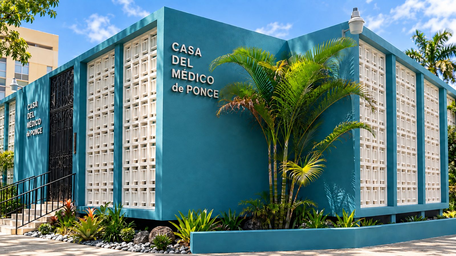 Fachada de la Casa del Médico de Ponce con su celosía blanca y jardín tropical